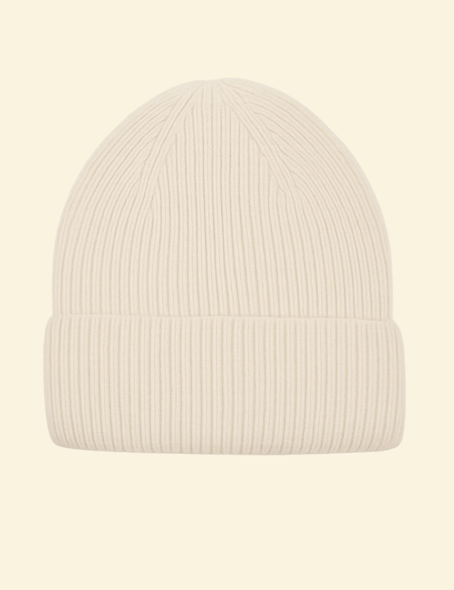 A cream-colored ribbed knit beanie made from a cozy cashmere-wool blend, displayed on a neutral background.