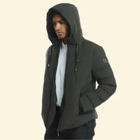 Model in dark green USB heated parka with hood up, hands in pockets