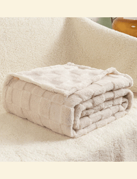 Beige Warmweave checkered blanket folded neatly on a soft cream sofa