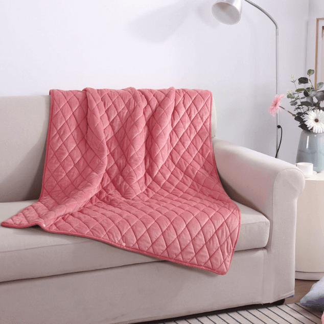 Ash Rose electric heated blanket placed on a light sofa for cozy warmth