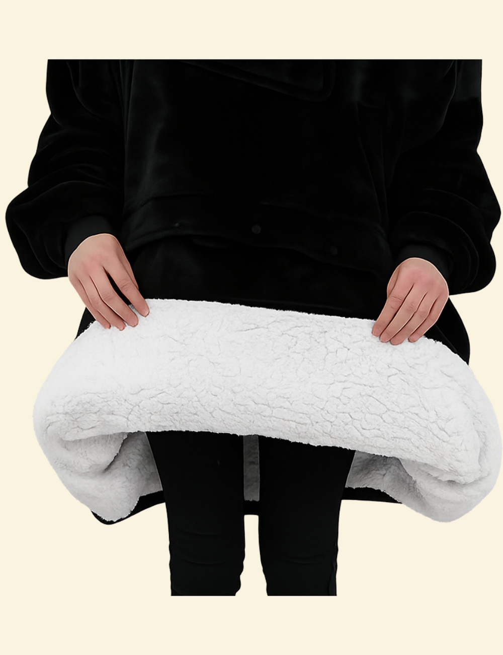 Hands lifting the edge of the black heated hoodie blanket to reveal white sherpa interior
