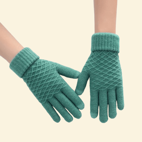 A pair of WarmWeave knit gloves in Pine Green featuring a diamond-knit texture and ribbed cuffs, displayed on a cream background.

